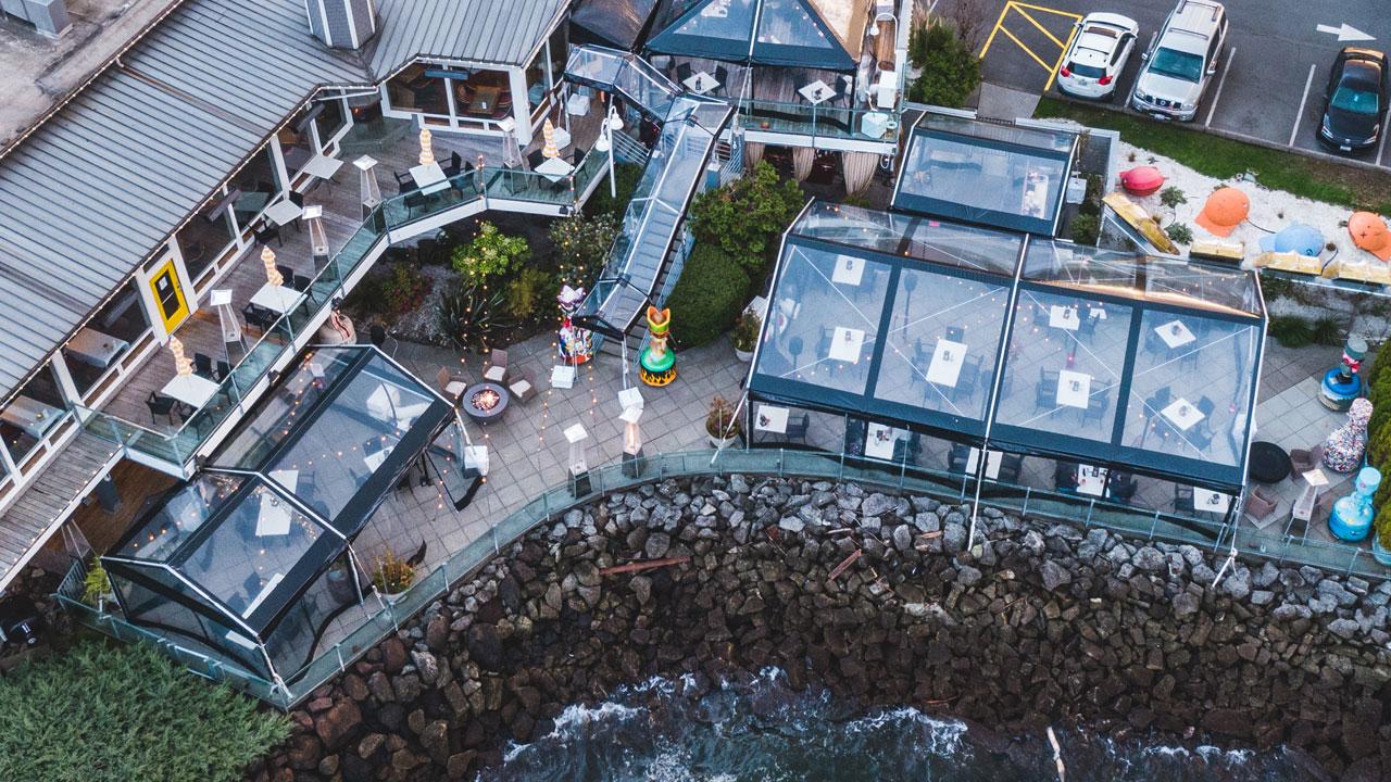 dramatic photo of clear tents on patio adjacent to the ocean